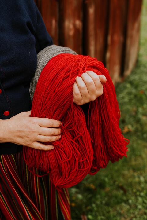 鲜红的纱线搭在一个女人的手上